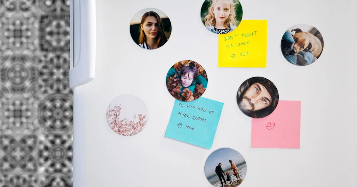 Circular photo magnets and colorful sticky notes with handwritten reminders on a refrigerator door